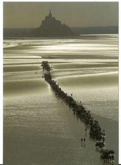 Mont St-Michel with pilgrims, off the coast of Avranches, Normandy, photo uncredited. The first monastery here was begun in the 8th century.