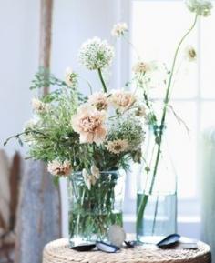 Garden or supermarket flowers in antique, washed-out tones take on a playfully unfettered feel in clear, casual vessels—and anyone can get the look.