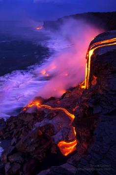 Molten lava cascades over a 30 foot cliff, creating new land at its base, Kilauea, Hawaii, USA