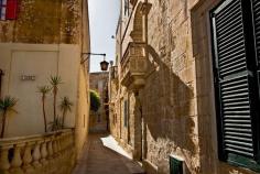 Walkway between the historic stone buildings in Mdina, the medieval walled town on the island of Malta