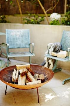 Firepit with weathered chairs.