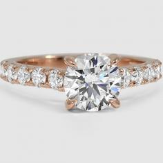 
                    
                        This luminous ring secures the center diamond with elegant claw prongs and features glamorous French pavé diamonds.
                    
                