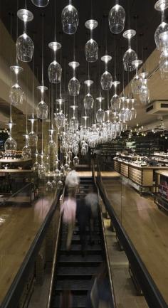 
                    
                        Hedonism Wines by Speirs + Major: Created from upended wine glasses mounted at varying heights, the organic sculptural form is inspired by the contour lines of a vineyard.  Individual LEDs illuminate each glass, forming a dazzling three-dimensional effect.
                    
                