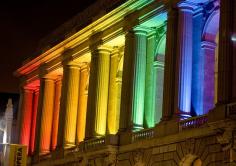 
                    
                        San Francisco Opera House at night, with rainbow colored lights to celebrate gay pride, the weekend of the parade.
                    
                